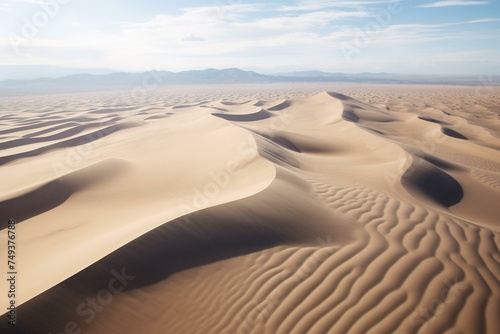 Aerial shot of wind-swept sand dunes  creating wavy patterns