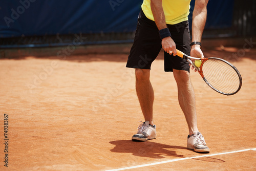 Tennis, sports and male player on court, outdoor turf and exercise for cardio fitness or fun. Racket, ball and athletic man with mockup space, training and practice for performance or competition © Katie/peopleimages.com