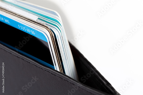 Macro detail closeup shot of several credit cards and multi-use cards neatly stacked inside a classic elegant black wallet. Personal private business and finance management, payment methods concept