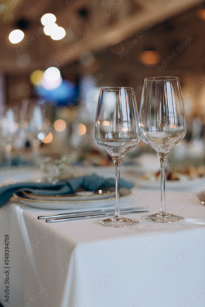 The table is set with elegant glasses for alcohol, napkins and tableware. Dinner service, catering, restaurant, formal dinner