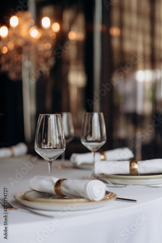 The table is set with elegant glasses for alcohol  napkins and tableware. Dinner service  catering  restaurant  formal dinner