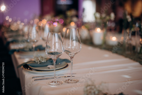 The table is set with elegant glasses for alcohol, napkins and tableware. Dinner service, catering, restaurant, formal dinner