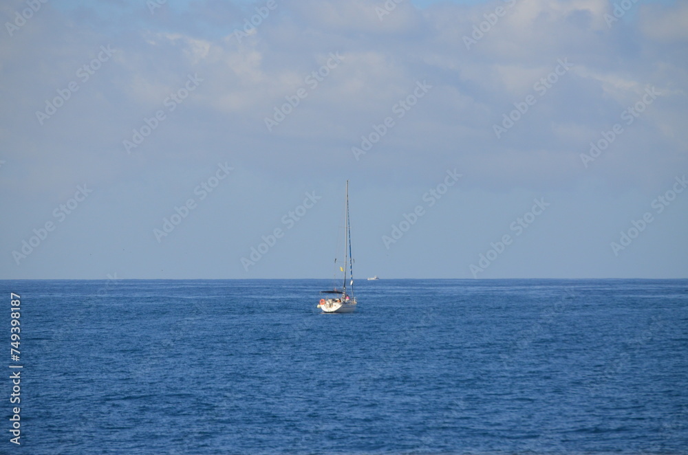 Sailing catamaran with open sails. Sailing catamaran in the middle of the sea in a tropical landscape Sailing catamaran with open sails. Sailing catamaran in the middle of the sea in a tropical landscape