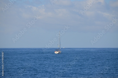 Sailing catamaran with open sails. Sailing catamaran in the middle of the sea in a tropical landscape