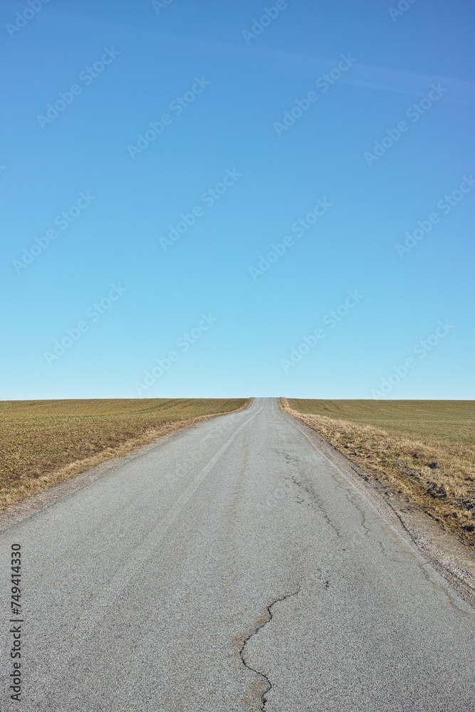 Blue sky, road trip and desert landscape for travel, holiday and natural scenery in countryside. Nature, horizon and street for journey, vacation or outdoor adventure with peace, relax and wilderness