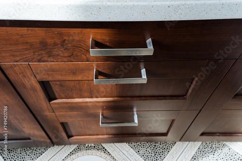 Close up of hardwood cabinet with stainless steel handles