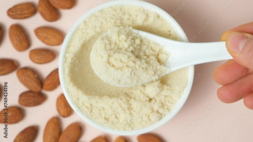 Cook shaking almond flour off spoon top view macro slow motion. Cook shaking almond flour off spoon top view macro slow motion.