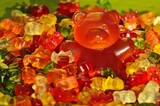 A teddy bear-shaped candy, sweet and colorful, evokes nostalgia with its charming design and sugary delight.