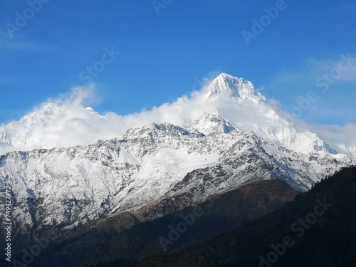 A majestic  snow-capped mountain reaching towards the endless blue skies  creating a breathtaking scene of natural beauty.