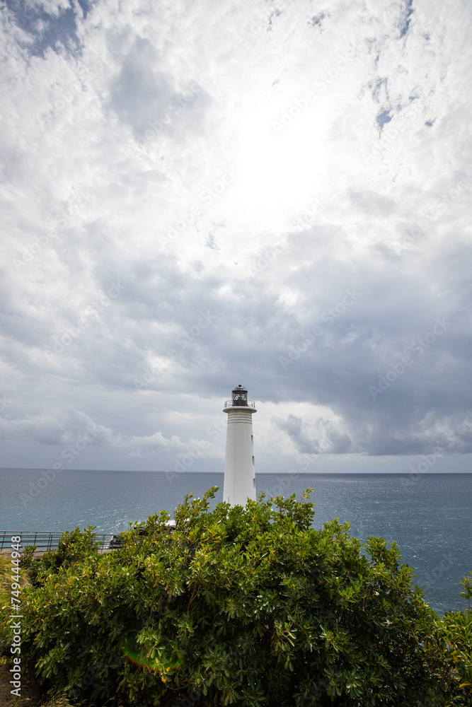 Le Phare du Vieux-Fort, white lighthouse on a cliff. Dramatic clouds overlooking the sea. Pure Caribbean on Guadeloupe, French Antilles, France