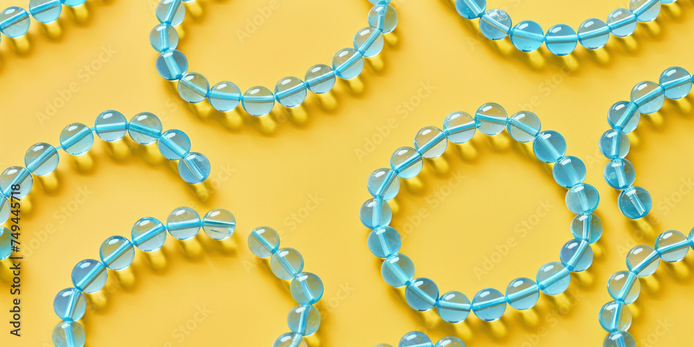 Blue and yellow beads with water and oxygen words on yellow background for scientific and educational concept images Blue and yellow beads with water and oxygen words on yellow background for scientific and educational concept images