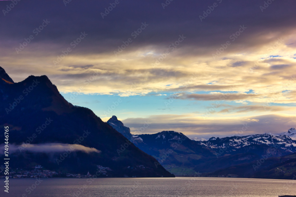 Fototapeta premium sunset in the mountains over the lake on a cloudy day