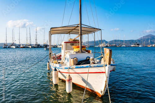 Traditional Greek fishing boat on blue sea in Adamas port bay, Milos island, Cyclades, Greece photo