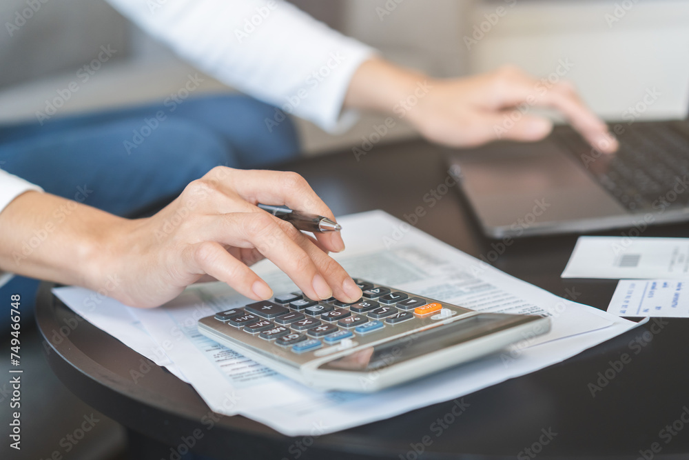 Deduction planning online asian young woman hand using calculator and laptop to calculate balance prepare tax reduction income, cost budget expenses for pay money form personal Individual Income. Deduction planning online asian young woman hand using calculator and laptop to calculate balance prepare tax reduction income, cost budget expenses for pay money form personal Individual Income.