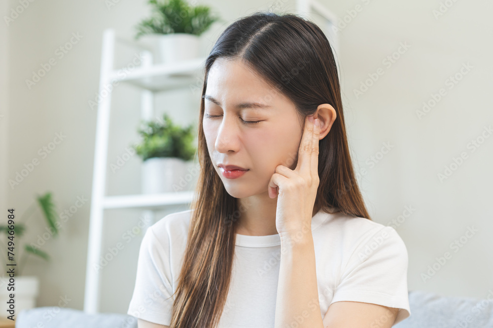 Tinnitus concept, sick asian young woman, girl have ear pain or earache, hand touch plug ear, suffering painful otitis from loud of noisy sound, inflammation. Health care nerve deaf eardrum disease. Tinnitus concept, sick asian young woman, girl have ear pain or earache, hand touch plug ear, suffering painful otitis from loud of noisy sound, inflammation. Health care nerve deaf eardrum disease.