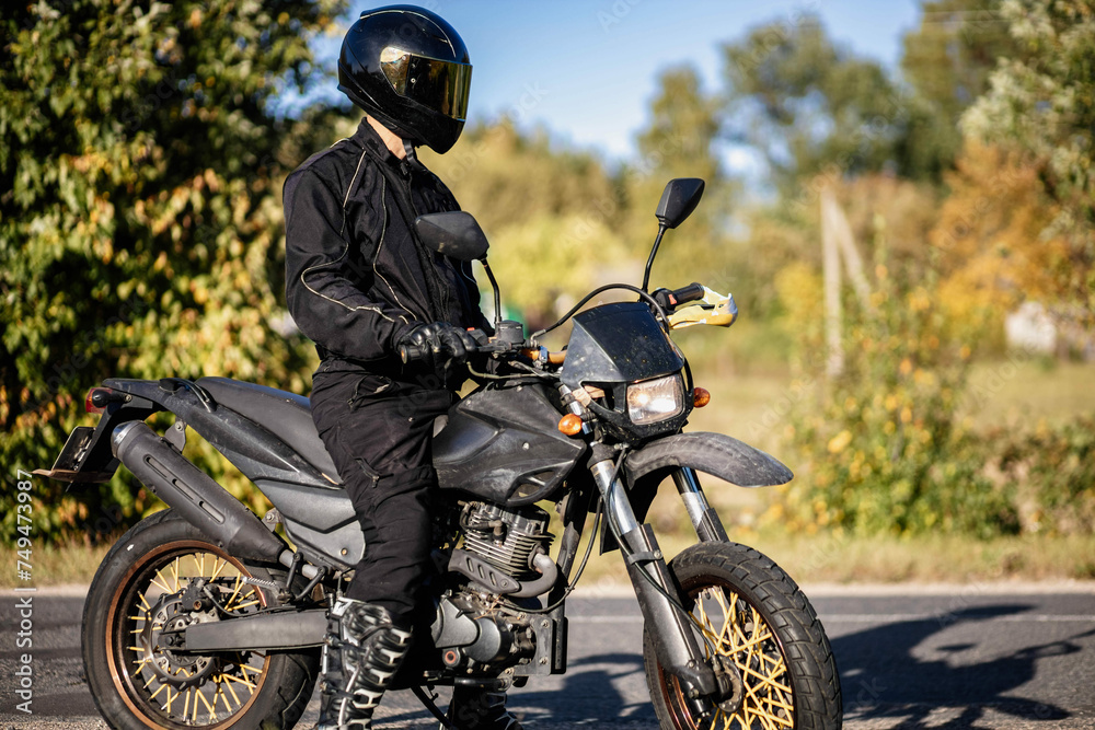 motorcyclist in extreme motorcycle equipment with an off-road enduro motorcycle