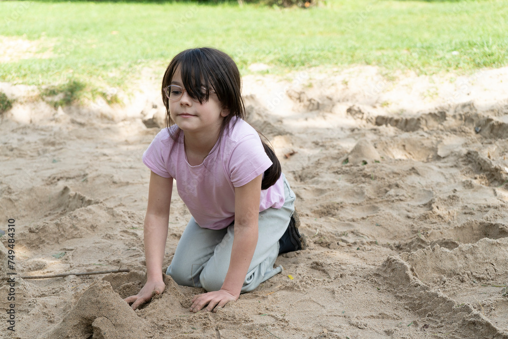 little girl playing in the sand in the park. shallow depth of field little girl playing in the sand in the park. shallow depth of field
