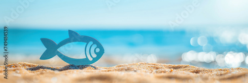 A bright, simplistic fish emblem on a sandy beach against a backdrop of sparkling ocean, suitable for whimsical or playful April Fools' Day themes or as a charming beach party invitation.