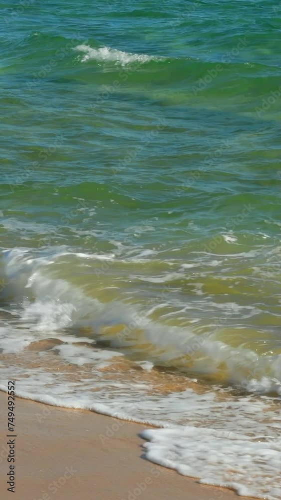 Ocean emerald waves splash on the yellow sand. The landscape is a relaxing seaside in sunny weather. Ocean emerald waves splash on the yellow sand. The landscape is a relaxing seaside in sunny weather.