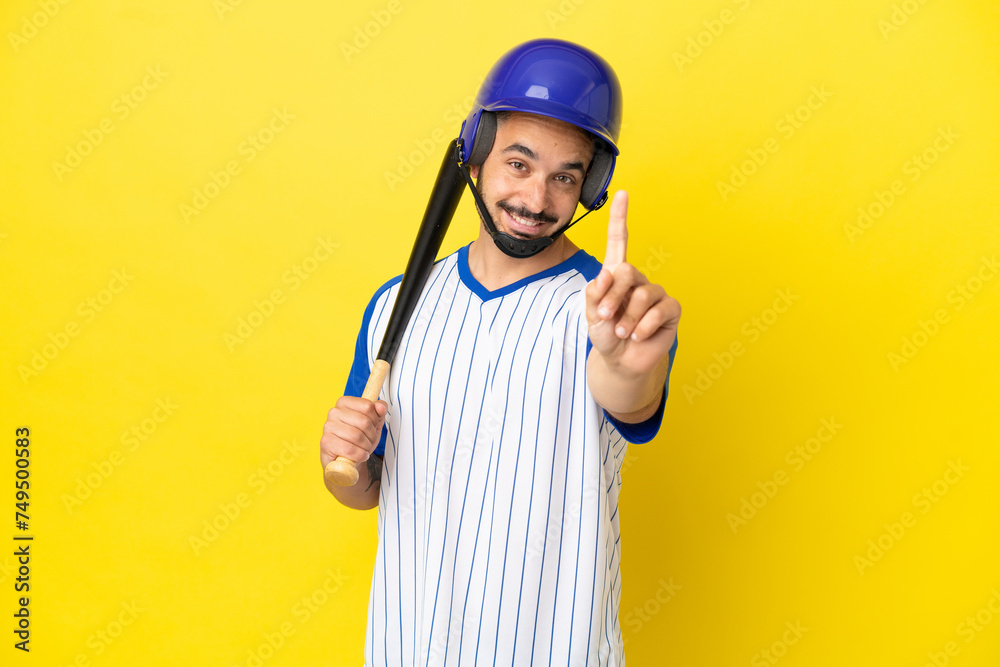 Young caucasian man playing baseball isolated on yellow background showing and lifting a finger Young caucasian man playing baseball isolated on yellow background showing and lifting a finger