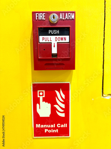 Wallpaper Mural Red fire alarm switch on a vibrant yellow wall with instructions Torontodigital.ca