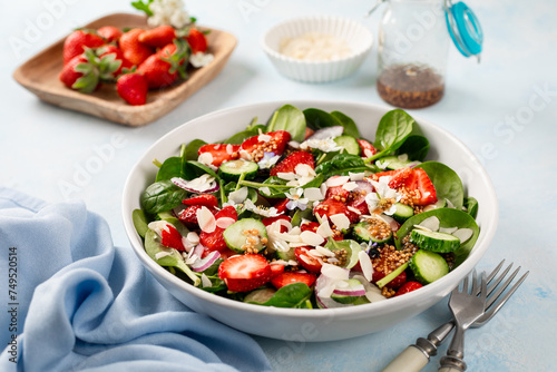 Strawberry spinach salad and balsamic dressing on a blue background