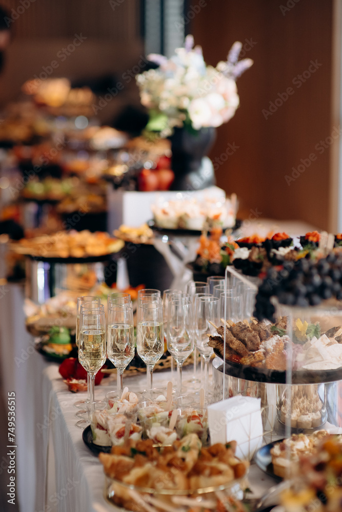 Food, a beautifully decorated catering banquet table with a variety of appetizers with cheese, ham, prosciutto and fruit. At a corporate, Christmas, birthday or wedding celebration. Buffet table. Buff