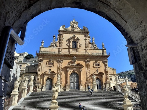 Il Duomo di San Pietro a Modica, incorniciato dall'arco di un vicolo. photo