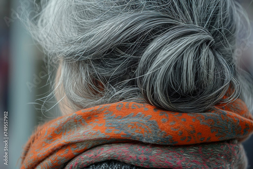 A close-up of head with gray hair and a scarf