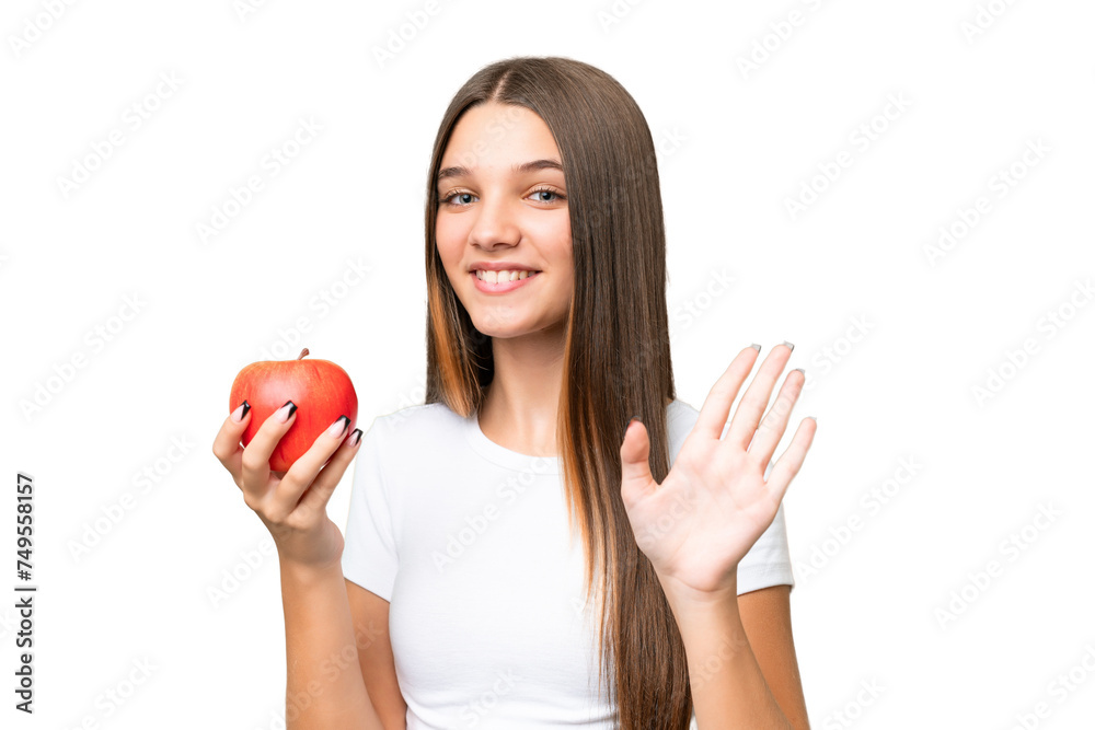 Teenager caucasian girl holding an apple over isolated background saluting with hand with happy expression Teenager caucasian girl holding an apple over isolated background saluting with hand with happy expression