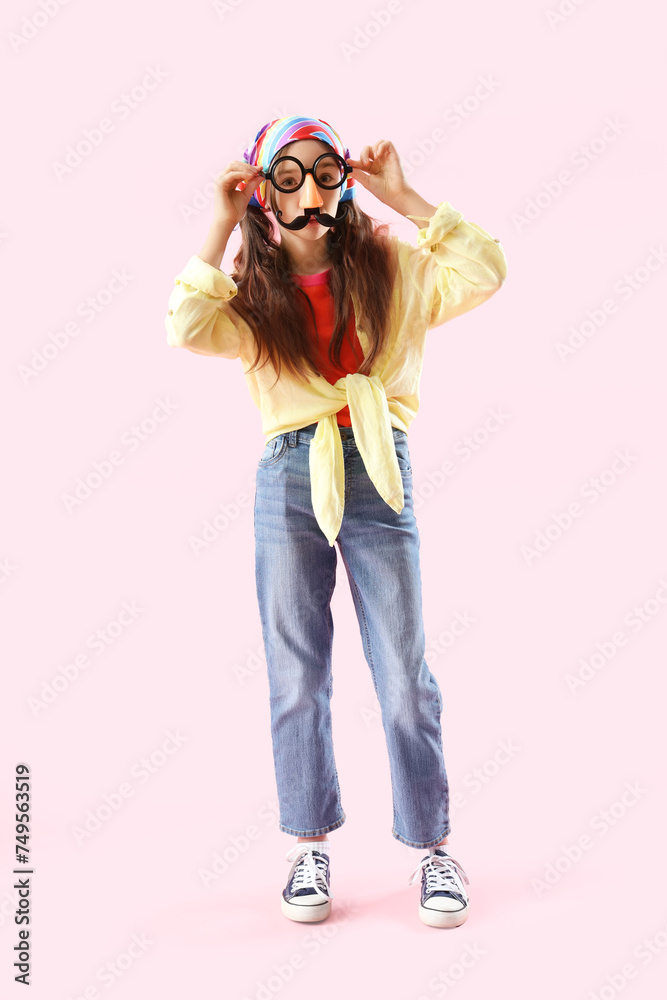 Funny little girl in disguise on pink background. April Fools' Day celebration Funny little girl in disguise on pink background. April Fools' Day celebration