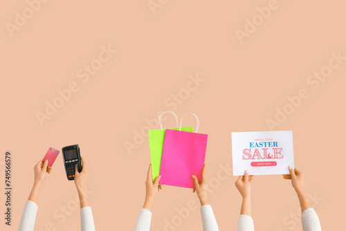 Women with payment terminal, credit card and shopping bags on beige background. Easter Sale