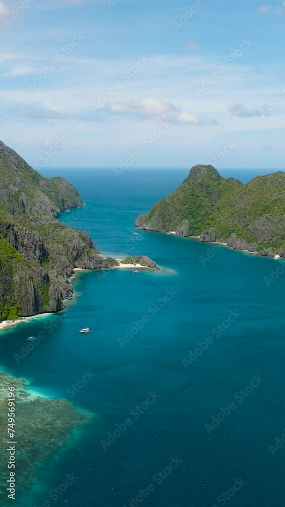 Blue sea with sun reflection. White beach in Tapiutan Island and Matinloc Island. El Nido, Palawan. Philippines. Vertical view. Blue sea with sun reflection. White beach in Tapiutan Island and Matinloc Island. El Nido, Palawan. Philippines. Vertical view.