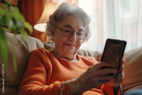 Grandma holding the smartphone in browsing wireless Internet, looking at screen, chatting in social network or shopping online, relax at home