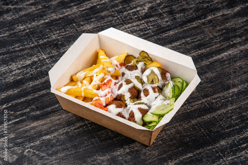 Falafel balls with fries and cucumber in lunch box
