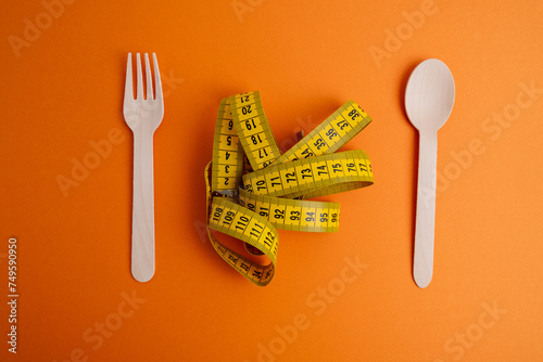 Yellow measuring tape on a light background. Tool for measuring length and volume. Tape for measuring in the clothing industry or the volume of the human body 
