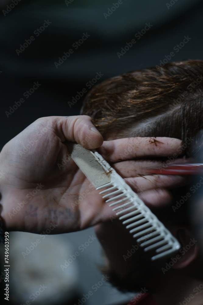 Naklejka premium Close-Up of Male Haircut: Hairdresser Trimming Hair in Modern Barber Style