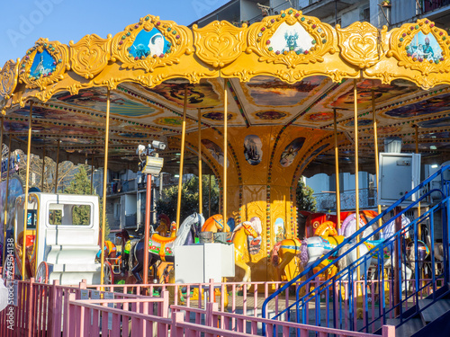 Amusement park in a residential area. Fun for kids. Carousels in the city park. photo