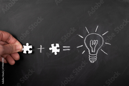 Solve puzzle combining the wisdom for developing new idea, drawing light bulb on blackboard.