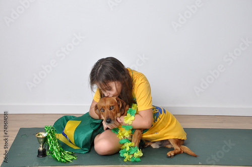 menina beijando cachorro vestido com cores do brasil carnaval  photo