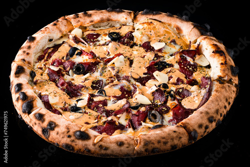 Pizza with beef, olives, garlic, cheese, sauce and spices isolated on black.