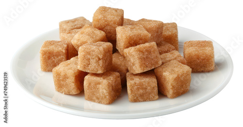 Natural brown sugar cubes piled on a white plate, cut out - stock png.