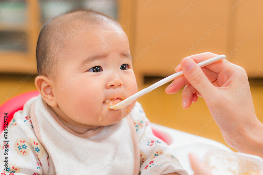 離乳食を食べている元気な赤ちゃん 離乳食を食べている元気な赤ちゃん