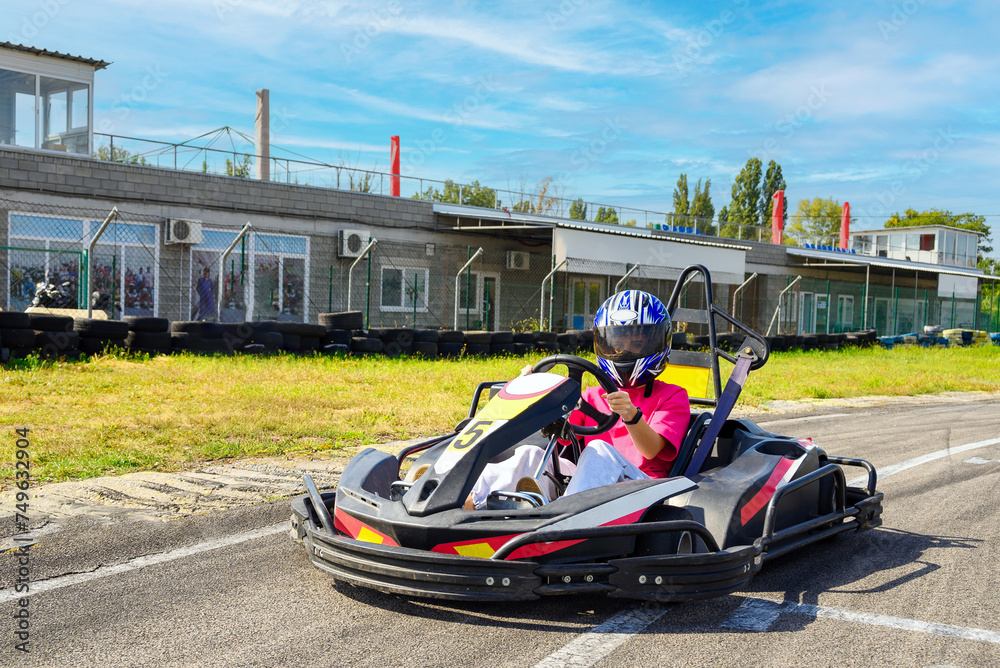 Teenage girl in a kart racing car at the start of a race
