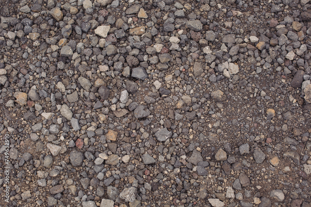 Background image of the surface covered with small gravel on the ground. Wallpaper. Substrate for text. Detailed texture of fine pebbles on the ground. The surface of the hiking trail. Top view. Background image of the surface covered with small gravel on the ground. Wallpaper. Substrate for text. Detailed texture of fine pebbles on the ground. The surface of the hiking trail. Top view.