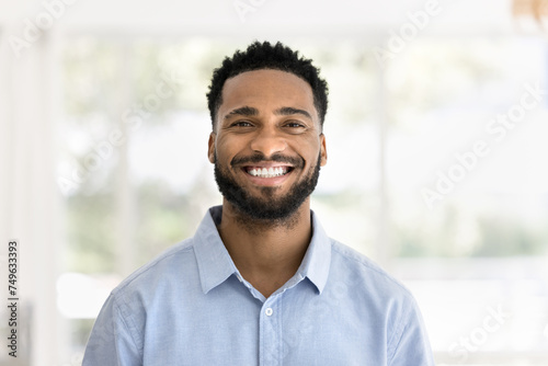 Cheerful handsome young African man head shot front portrait. Happy positive attractive male entrepreneur, startup leader, business professional in casual looking at camera with toothy smile photo