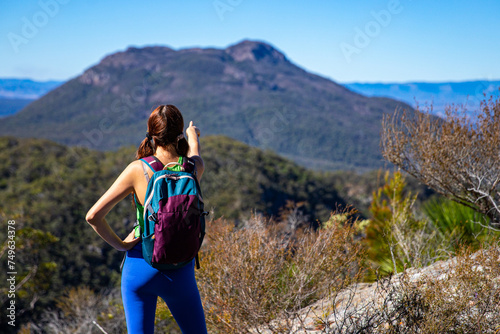 hiker girl looking at the peak of mount maroon from the top of mount may in mount barney national park, south east queensland, australia