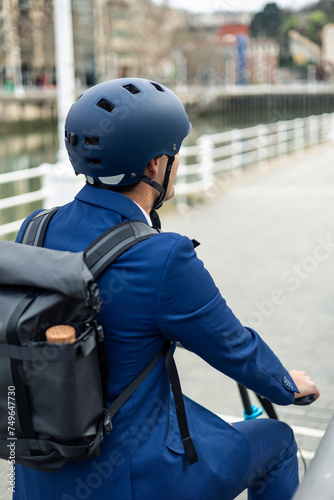 vertical portrait closeup from back of Man Riding Electric Bike to Work in Urban Setting