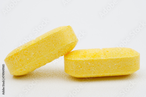 Single yellow tablet against blue background
