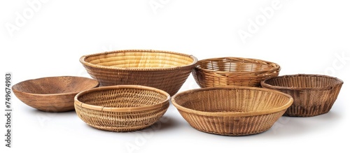 Several empty wicker bowls and baskets are arranged neatly on a plain white background, highlighting traditional handmade craftsmanship.